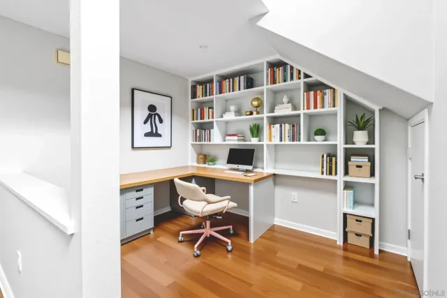 a view of a workspace with furniture and a book shelf