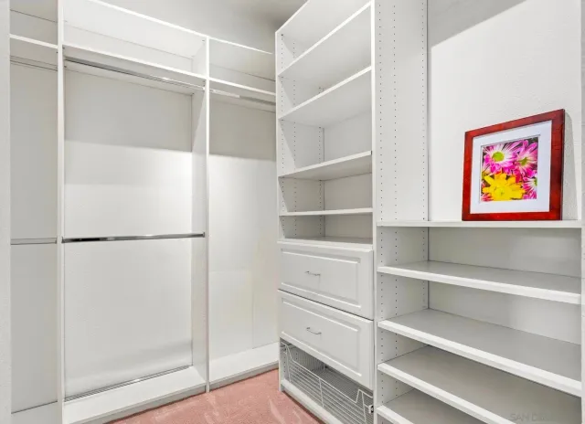 a view of walk in closet with empty racks