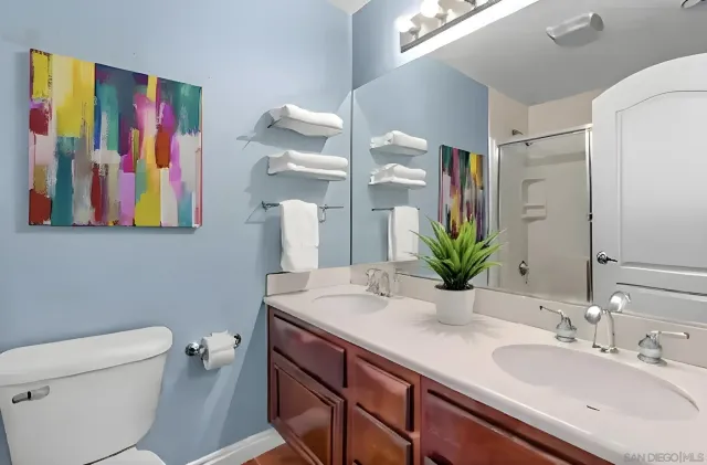 a bathroom with a sink a large mirror and a toilet