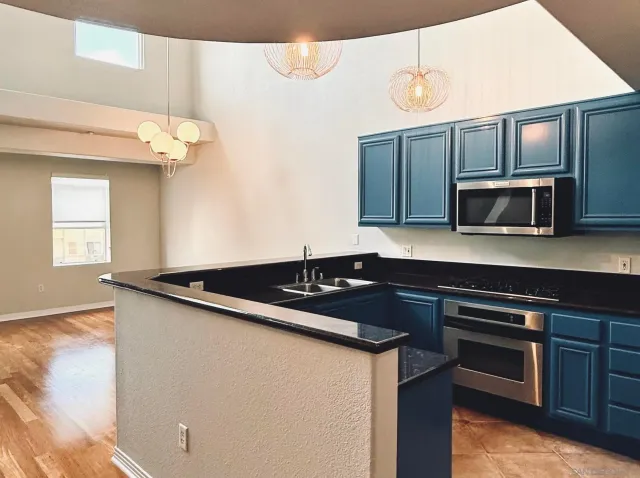 a kitchen with granite countertop a sink cabinets and stainless steel appliances