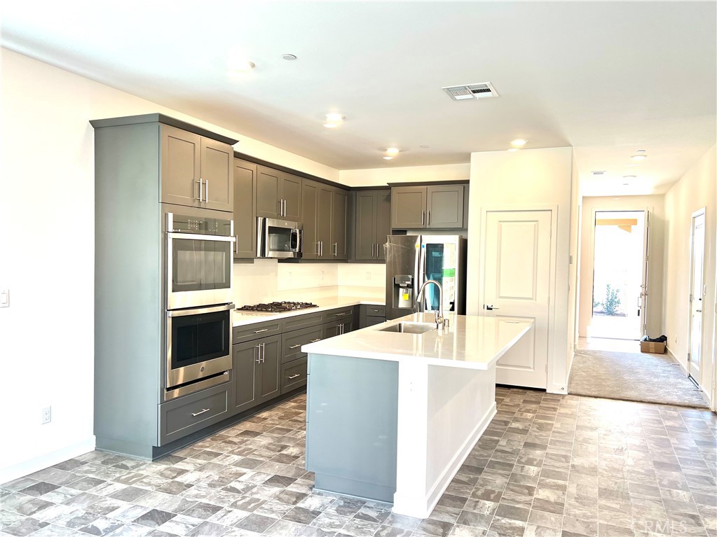 2595 Pheasant Way Ontario, CA 91761 - Photo 14 of 34 a large kitchen with kitchen island a sink stainless steel appliances and cabinets