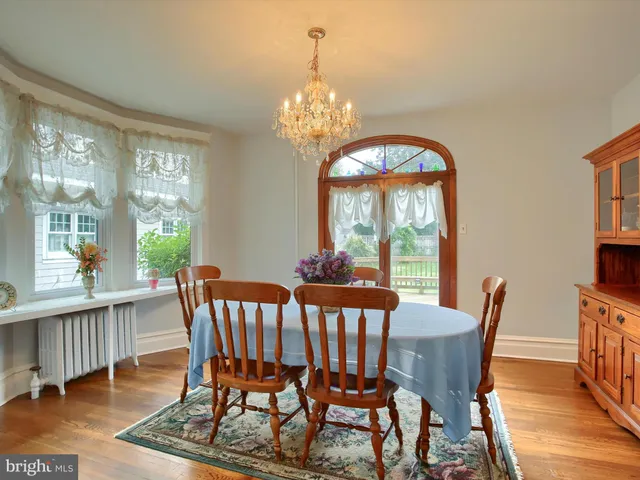 a view of a dining room with furniture a chandelier and wooden floor