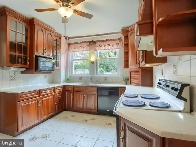 a kitchen with stainless steel appliances granite countertop a sink a stove and cabinets