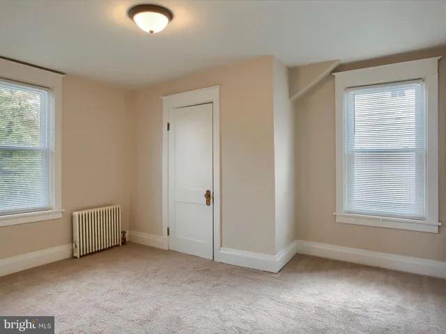 an empty room with windows and closet