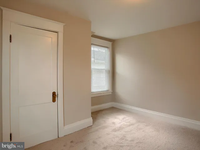 an empty room with closet area and window