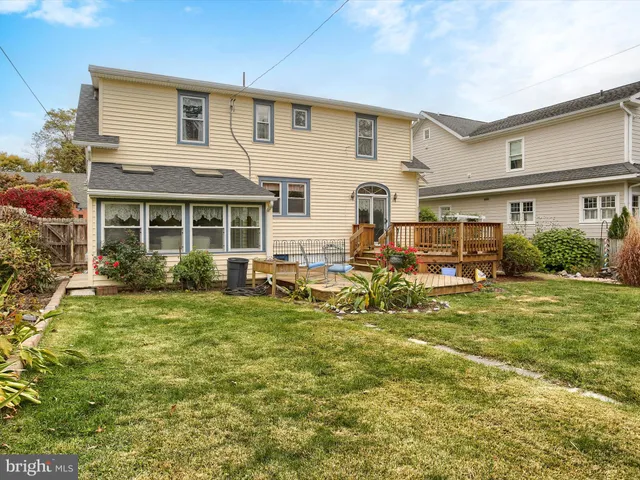 a view of a house with a big yard plants and large trees