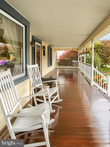 a view of a patio with dining table and chairs with wooden floor and fence