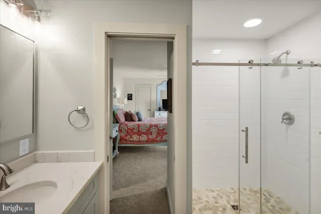 a view of a swimming pool with chairs and wooden fence