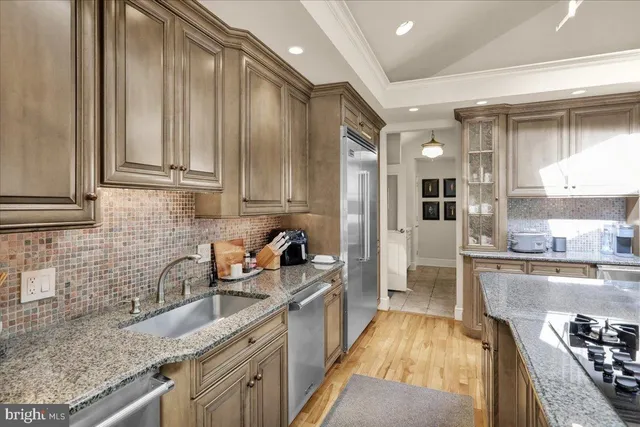 a kitchen with stainless steel appliances granite countertop a stove and a refrigerator
