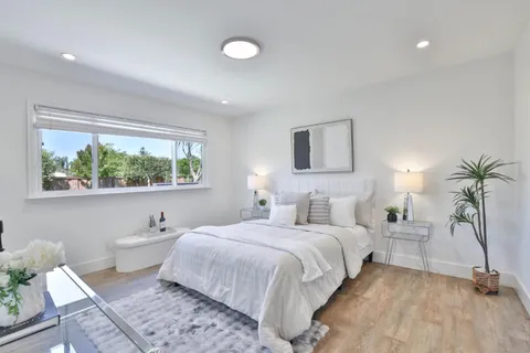 a bedroom with a large bed and a potted plant