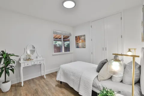 a bedroom with a bed and a potted plant