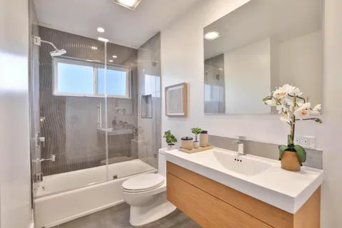 a bathroom with a sink a toilet and shower