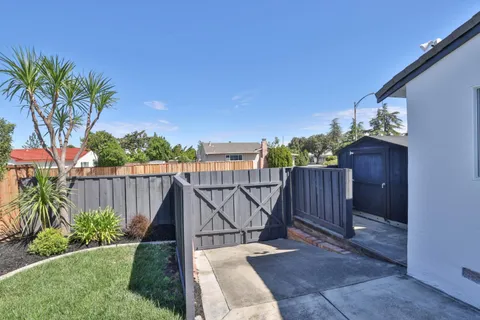 a view of a balcony with wooden fence and potted plants