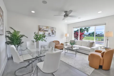 a living room with furniture potted plant and a large window