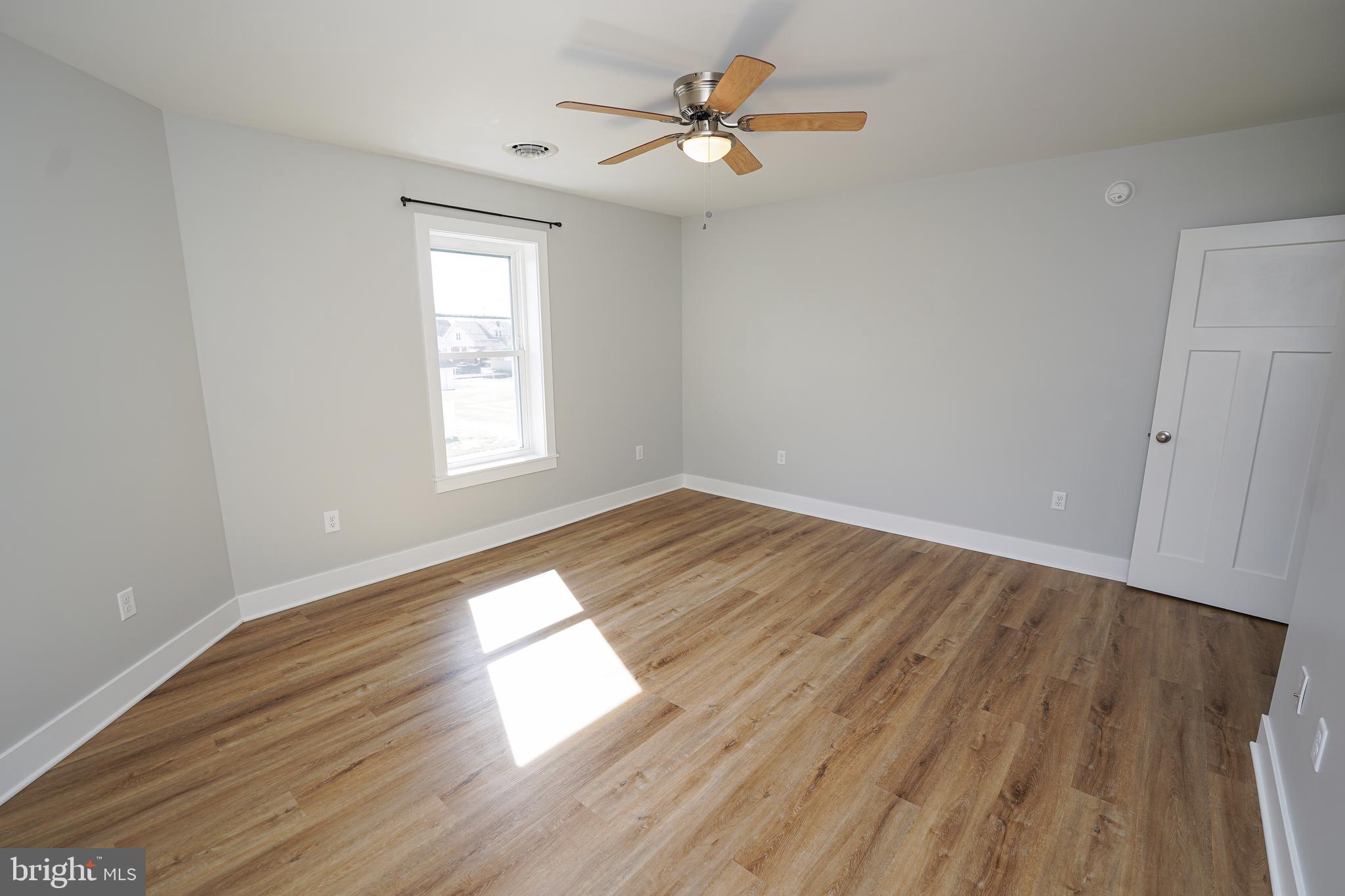 111 East Jewell Street Delmar, DE 19940 - Photo 41 of 59 an empty room with wooden floor and windows