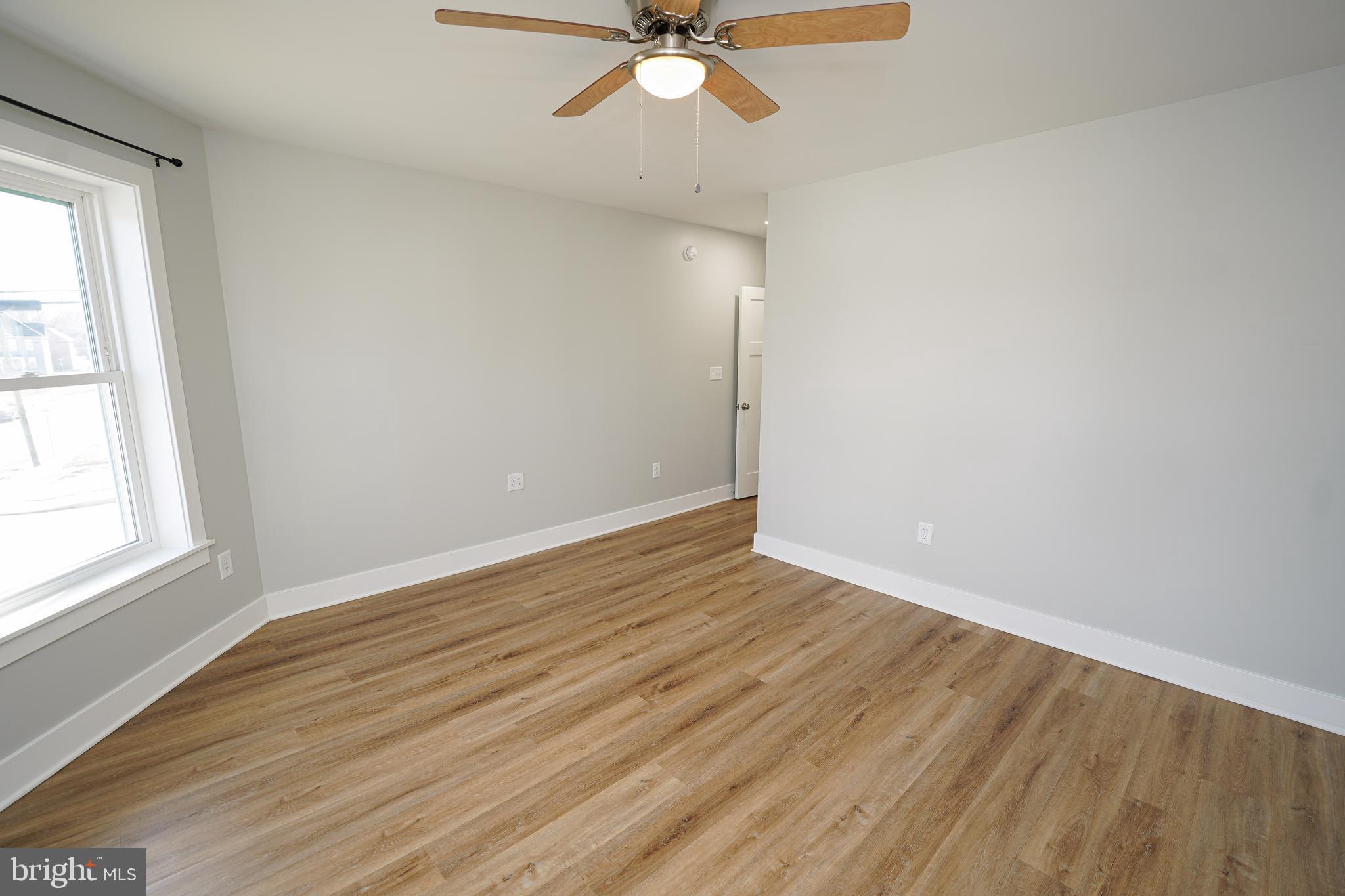 111 East Jewell Street Delmar, DE 19940 - Photo 45 of 59 an empty room with wooden floor fan and windows
