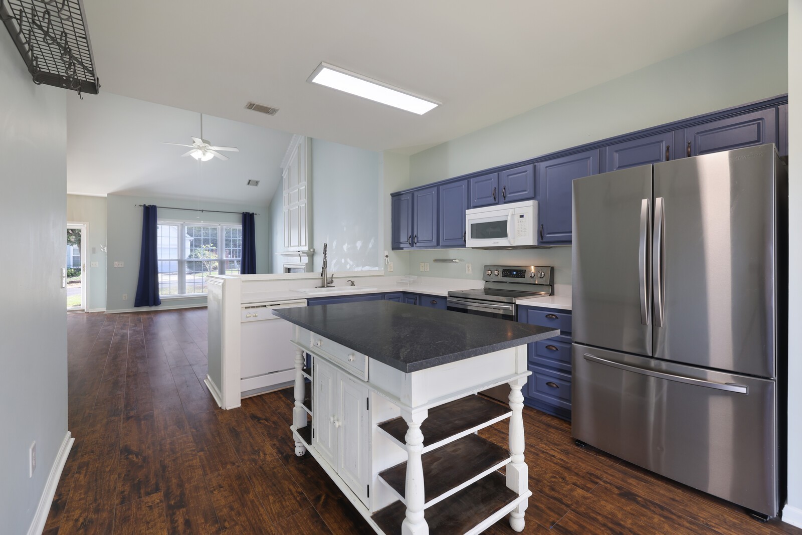 a kitchen with a refrigerator a sink and a stove top oven