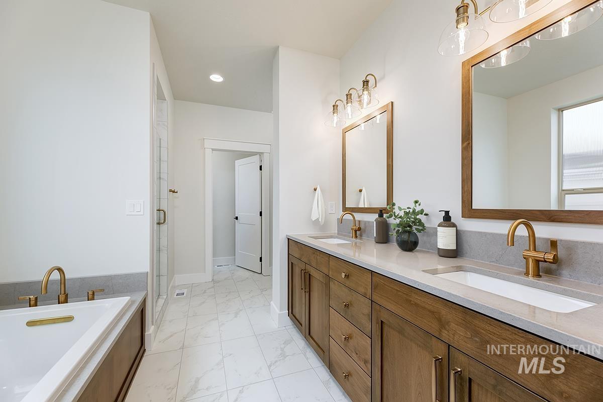 3281 East Englehart Lane Meridian, ID 83642 - Photo 11 of 35 Bathroom featuring double vanity, light marble finish floors, a shower stall, a garden tub, and recessed lighting