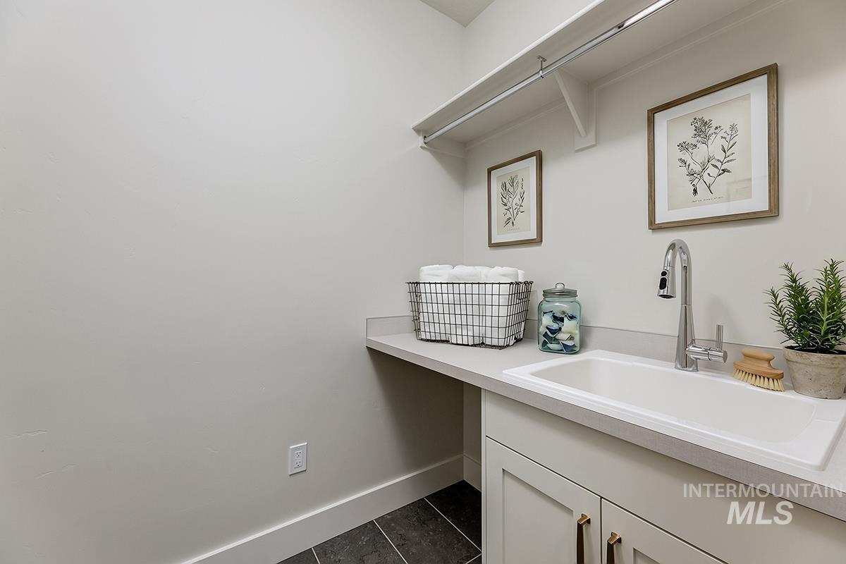3281 East Englehart Lane Meridian, ID 83642 - Photo 17 of 35 Laundry area featuring a sink and dark tile patterned flooring