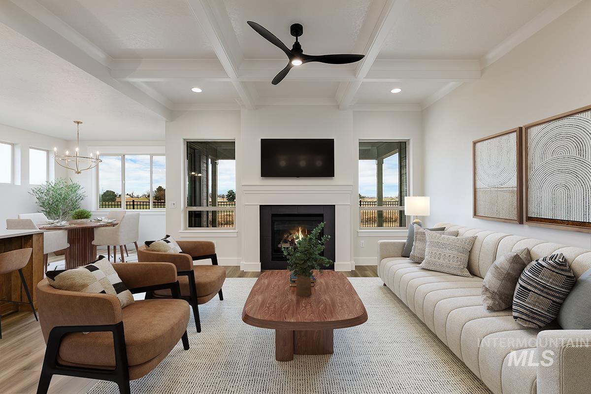 3281 East Englehart Lane Meridian, ID 83642 - Photo 3 of 35 Living area featuring a ceiling fan, light wood finished floors, coffered ceiling, a warm lit fireplace, and suspended lighting
