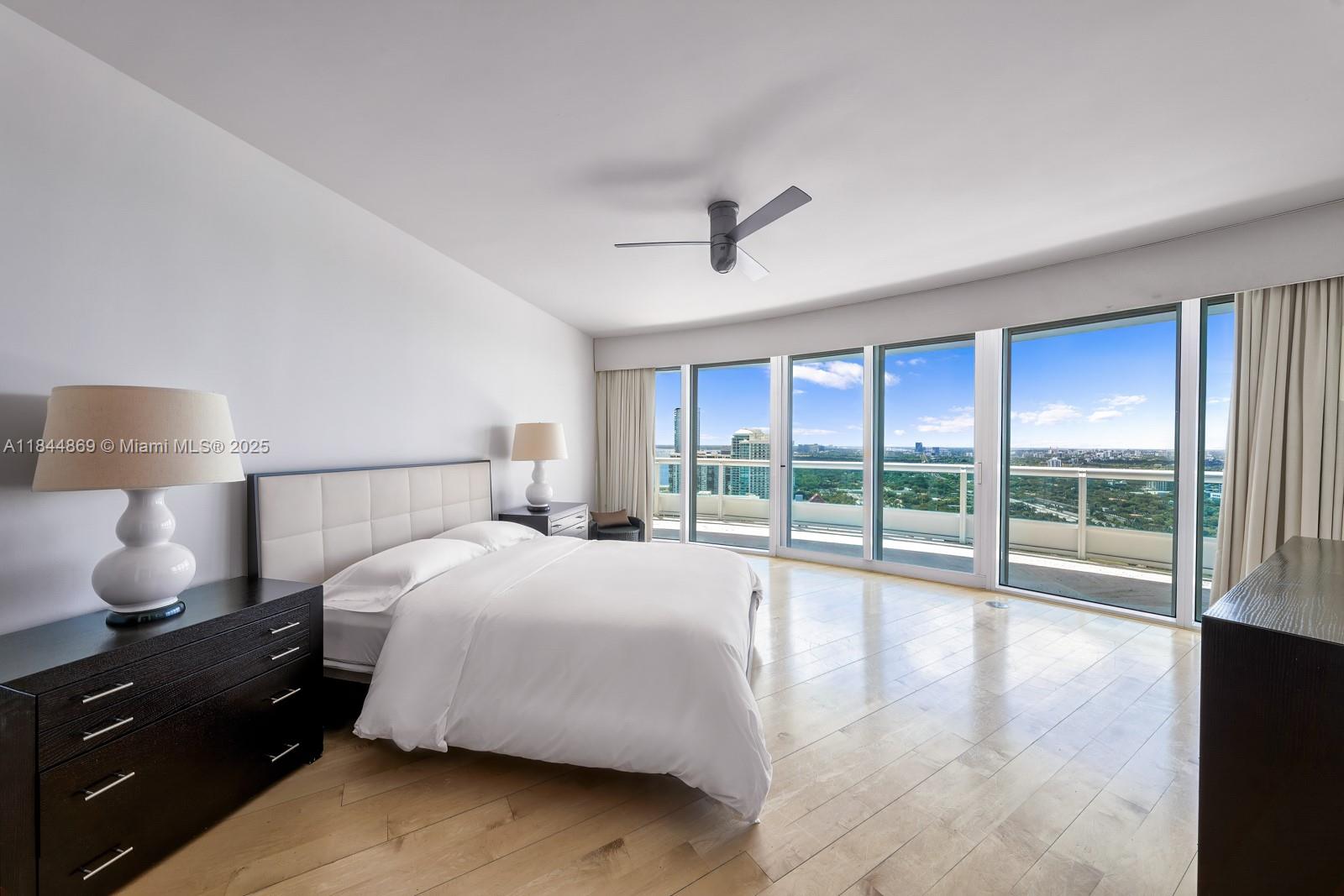 1643 Brickell Avenue, Unit 3702 Miami, FL 33129 - Photo 17 of 32 a spacious bedroom with a large bed and a lamp on table