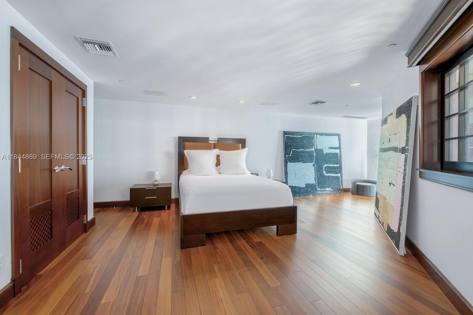 1643 Brickell Avenue, Unit 3702 Miami, FL 33129 - Photo 21 of 32 a bedroom with a bed and wooden floor