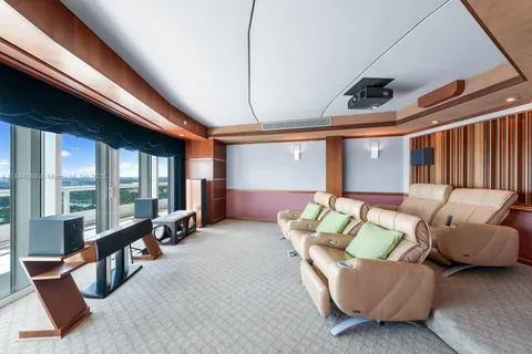 a living room with furniture a ceiling fan and a large window