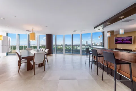 a dining room with furniture and a floor to ceiling window
