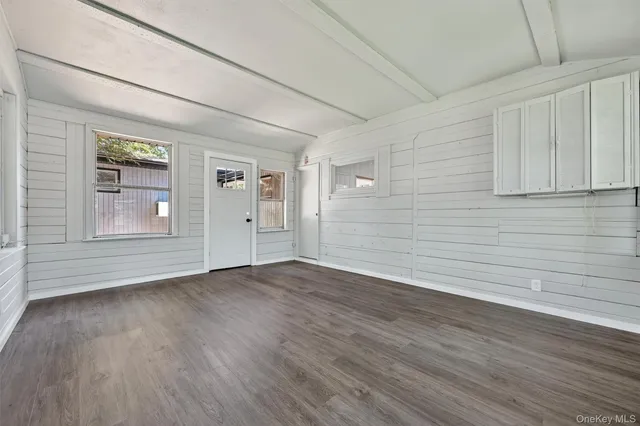 a view of empty room with wooden floor and entryway