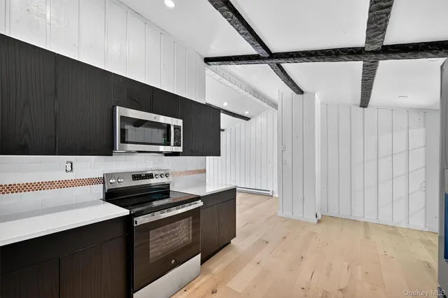 a kitchen with stainless steel appliances a stove top oven a sink and a microwave