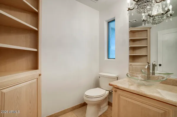 a bathroom with a granite countertop toilet sink and mirror
