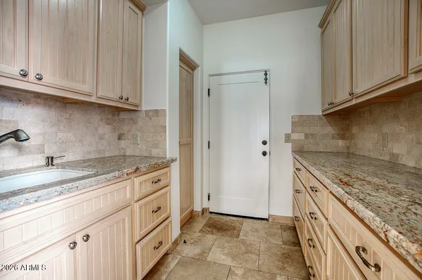 a kitchen with granite countertop white cabinets and white appliances