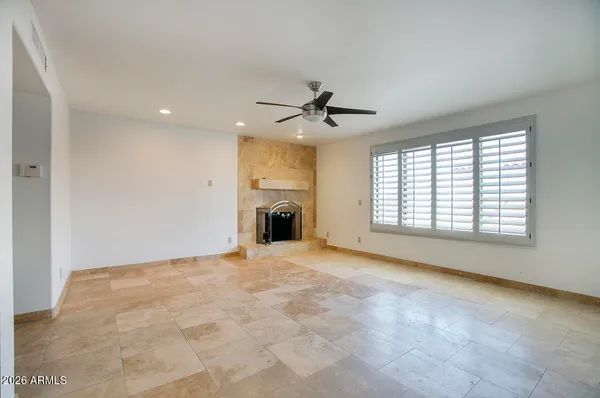 a view of an empty room with a fireplace and a window