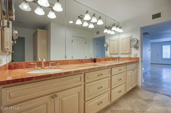 a bathroom with a granite countertop double vanity sink and a mirror