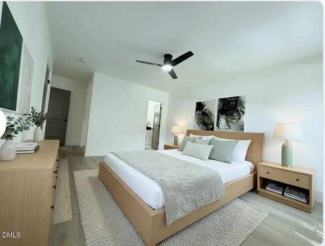 a bedroom with a large bed and a chandelier