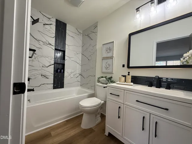 a bathroom with a sink toilet a mirror and shower