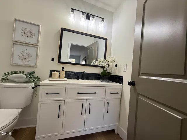 a bathroom with a toilet sink and mirror