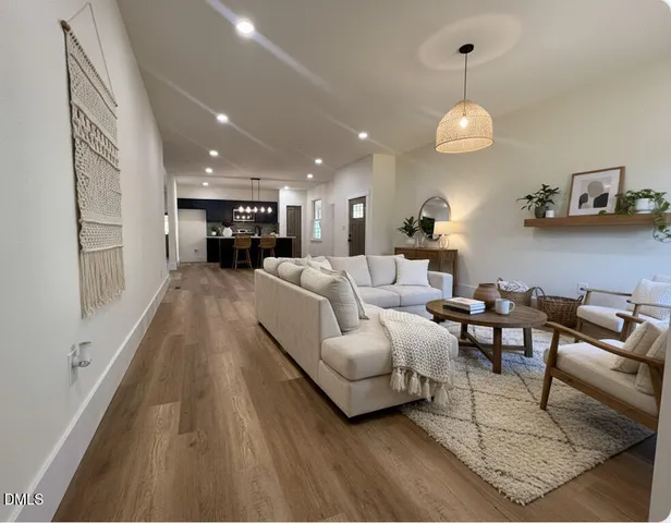 a living room with furniture and a wooden floor