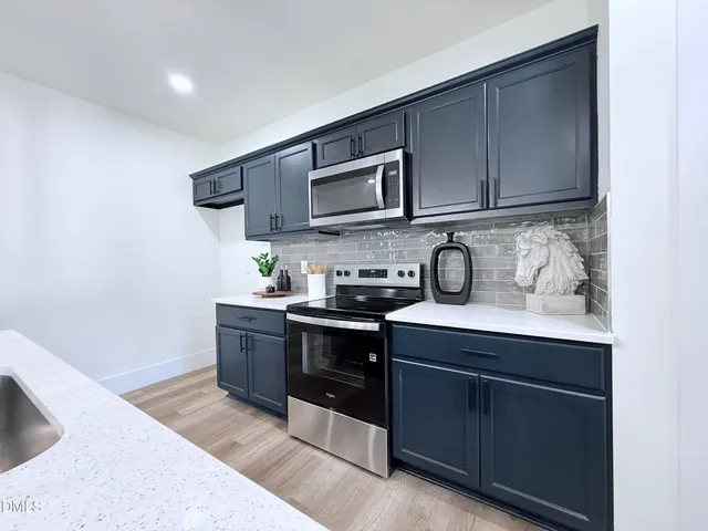 a kitchen with stainless steel appliances granite countertop a sink stove and cabinets