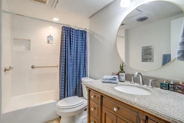a bathroom with a granite countertop sink toilet and shower