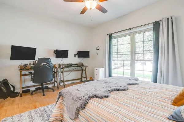 a spacious bedroom with a bed a table and a large window