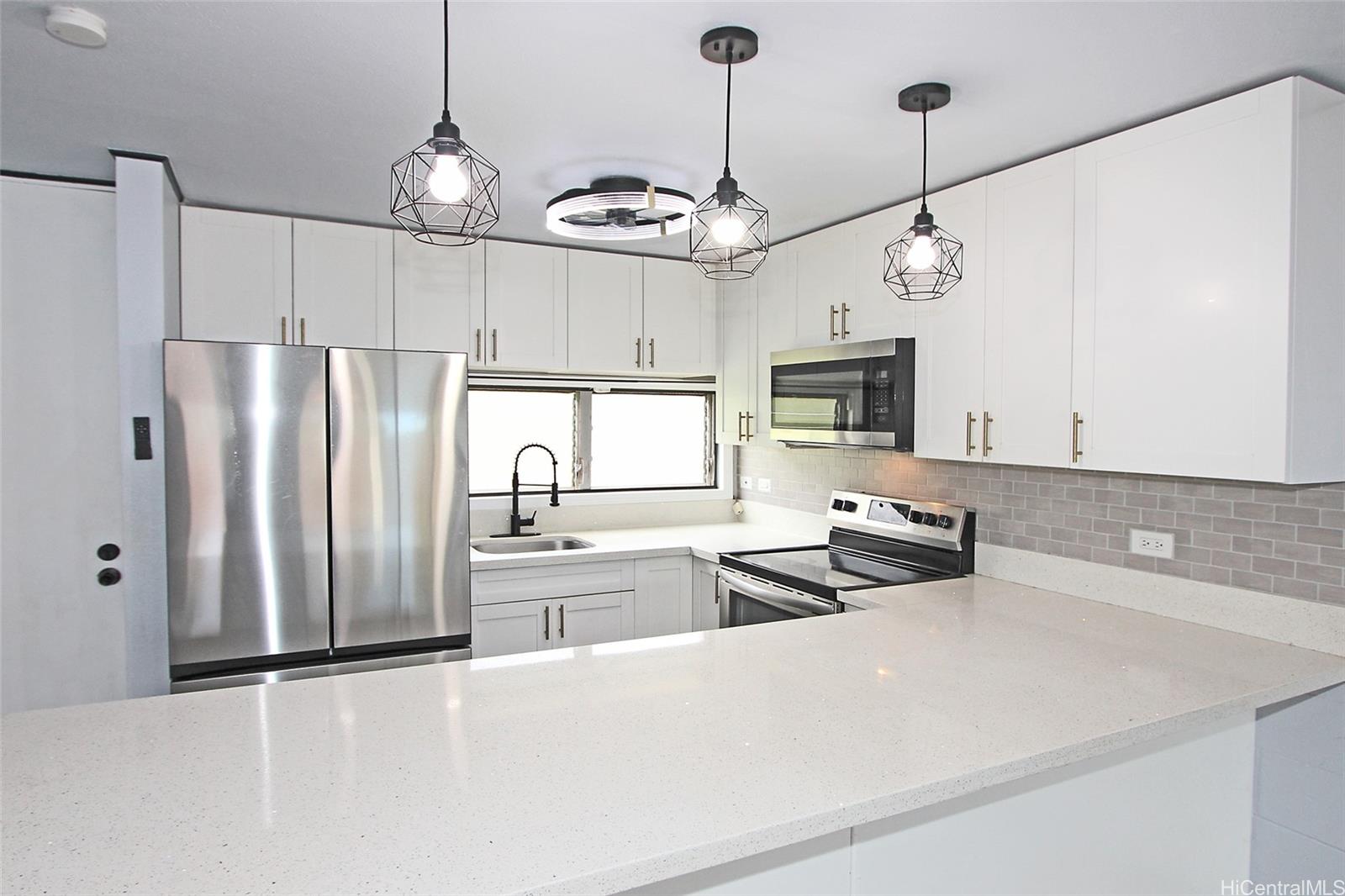 a kitchen with stainless steel appliances granite countertop a refrigerator a sink and a stove
