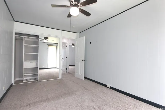 a view of a bedroom with closet and a ceiling fan