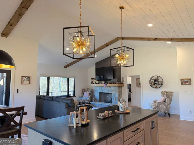 a kitchen with stainless steel appliances granite countertop a stove a refrigerator a kitchen island a dining table and chairs