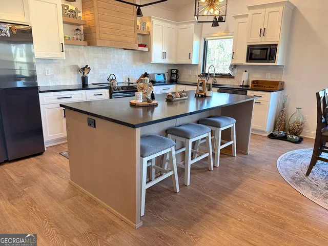 a kitchen with a dining table chairs and wooden floor