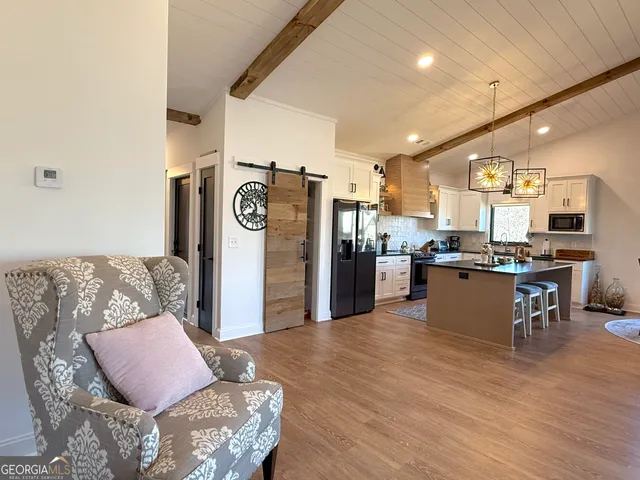 a living room with lots of furniture and kitchen view