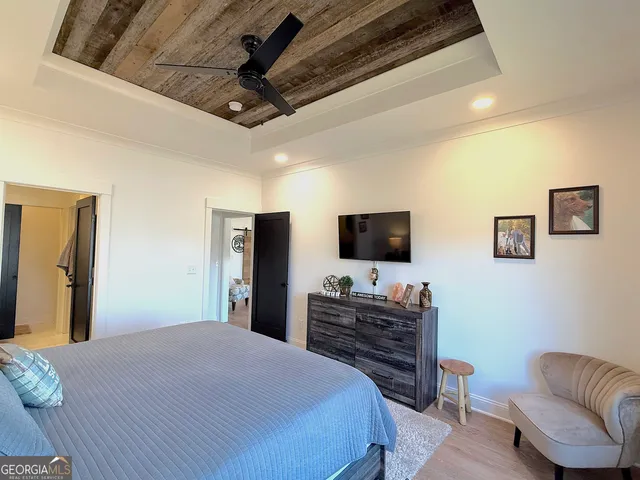 a bedroom with a large bed and a chandelier