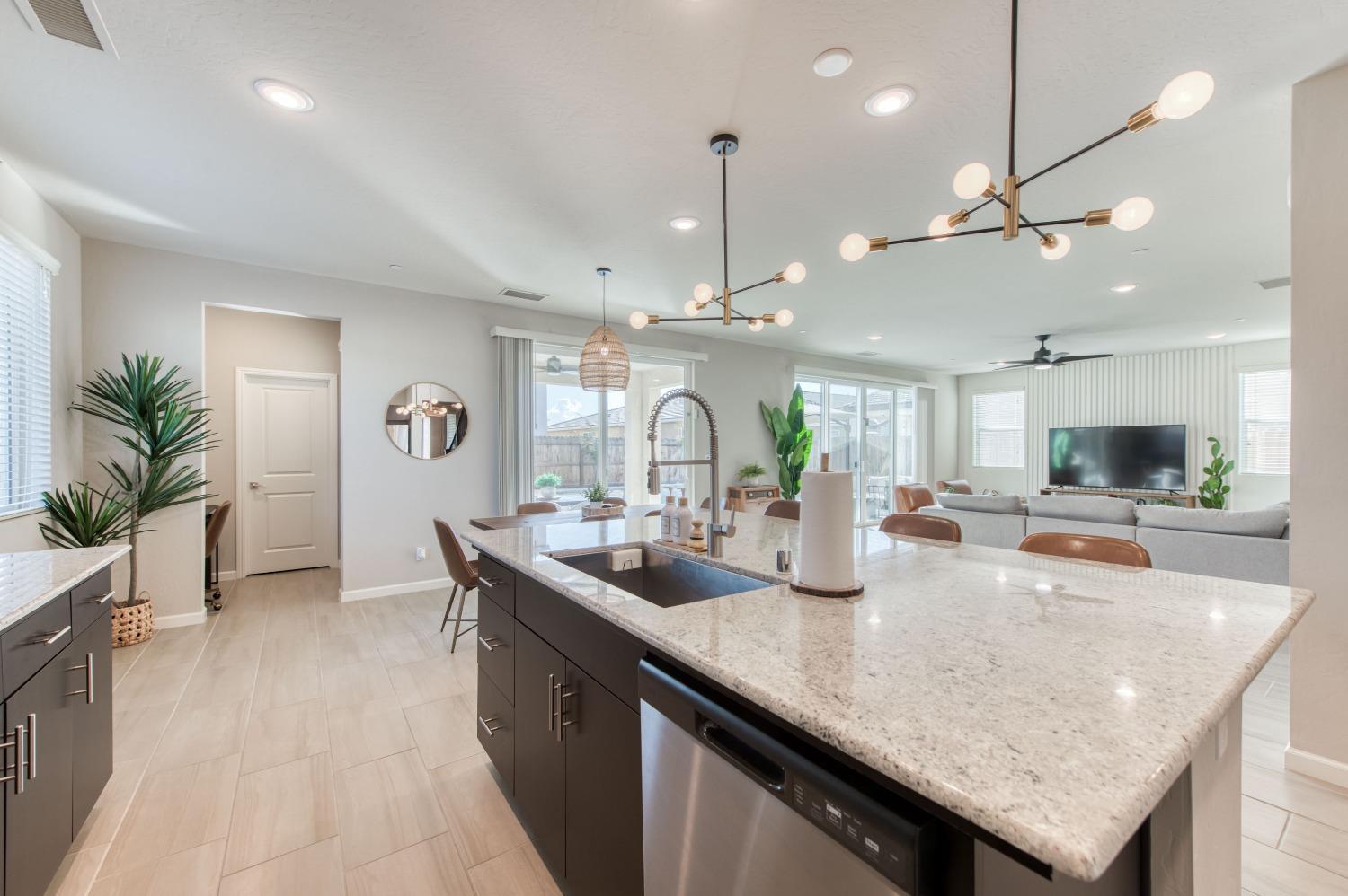 4136 Mecca Avenue Clovis, CA 93619 - Photo 15 of 44 a kitchen with granite countertop a sink a counter top space and living room view