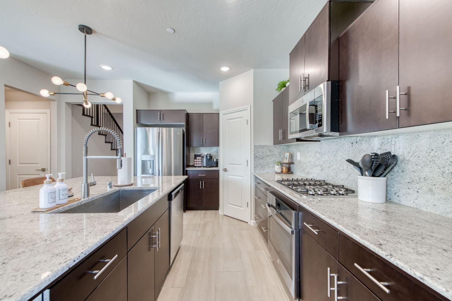 4136 Mecca Avenue Clovis, CA 93619 - Photo 16 of 44 a large kitchen with stainless steel appliances granite countertop a sink stove and refrigerator