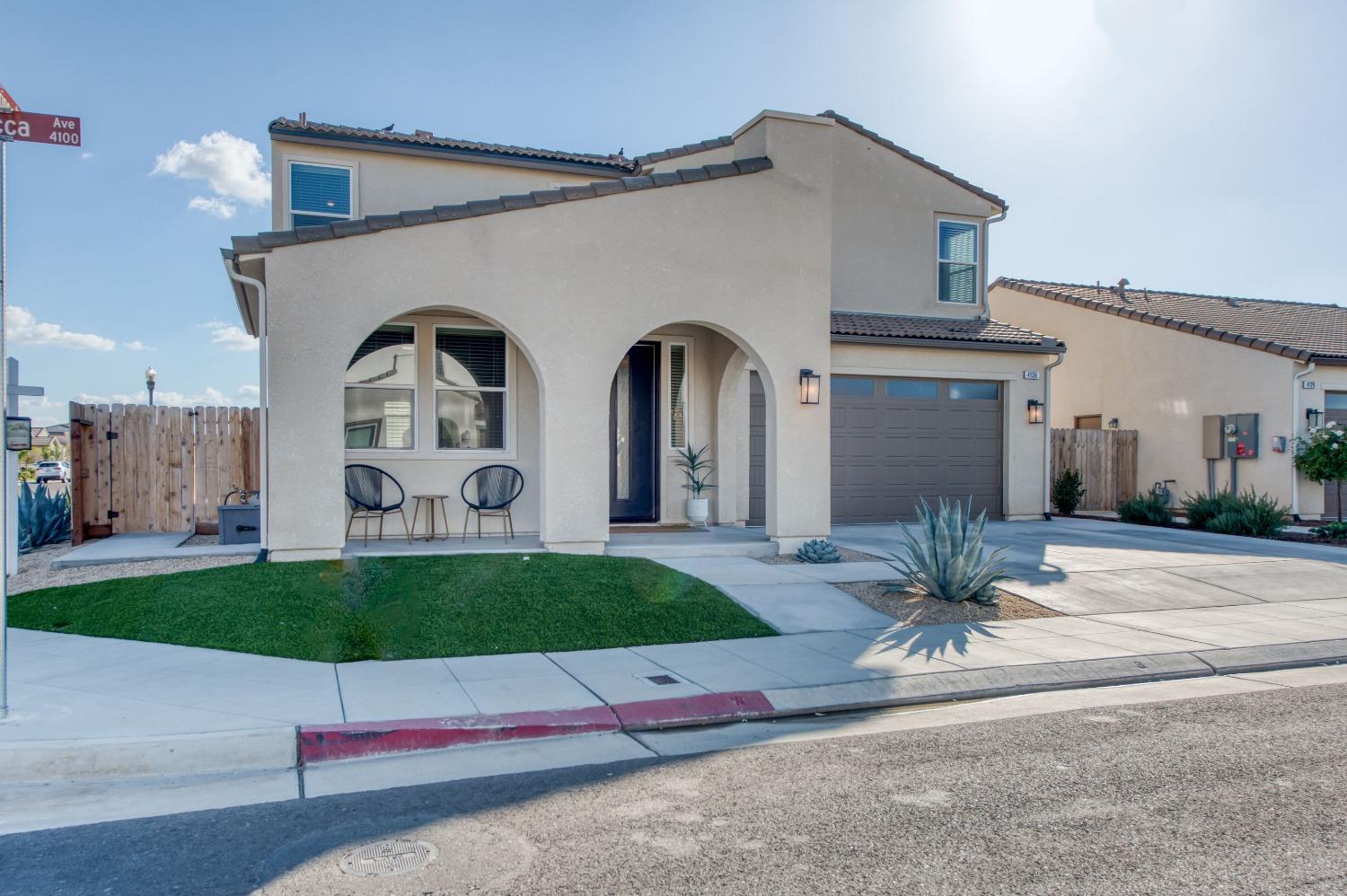 4136 Mecca Avenue Clovis, CA 93619 - Photo 7 of 44 a front view of a house with a yard and potted plants